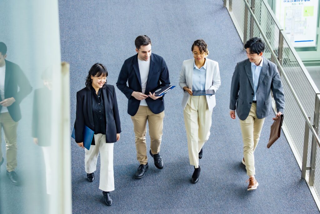 4 business people walking in professional attire possibly discussing how to register as a foreign entity 