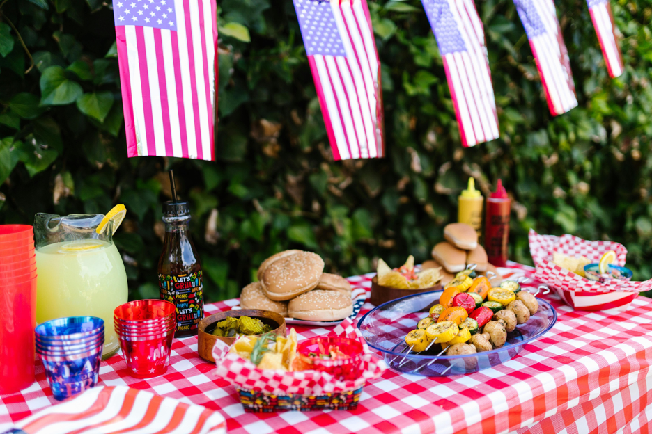 picnic with lemonade and hot dogs with American flags hanging 