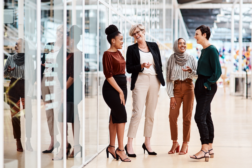 minority business women meeting and talking in a office building hallway