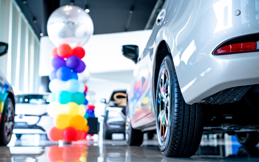 car dealership with 2 cars visible and a balloon arch