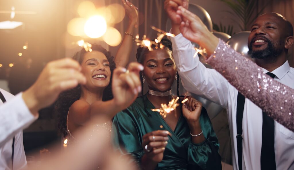 business people cheering with sparklers in fancy clothes celebrating the new year