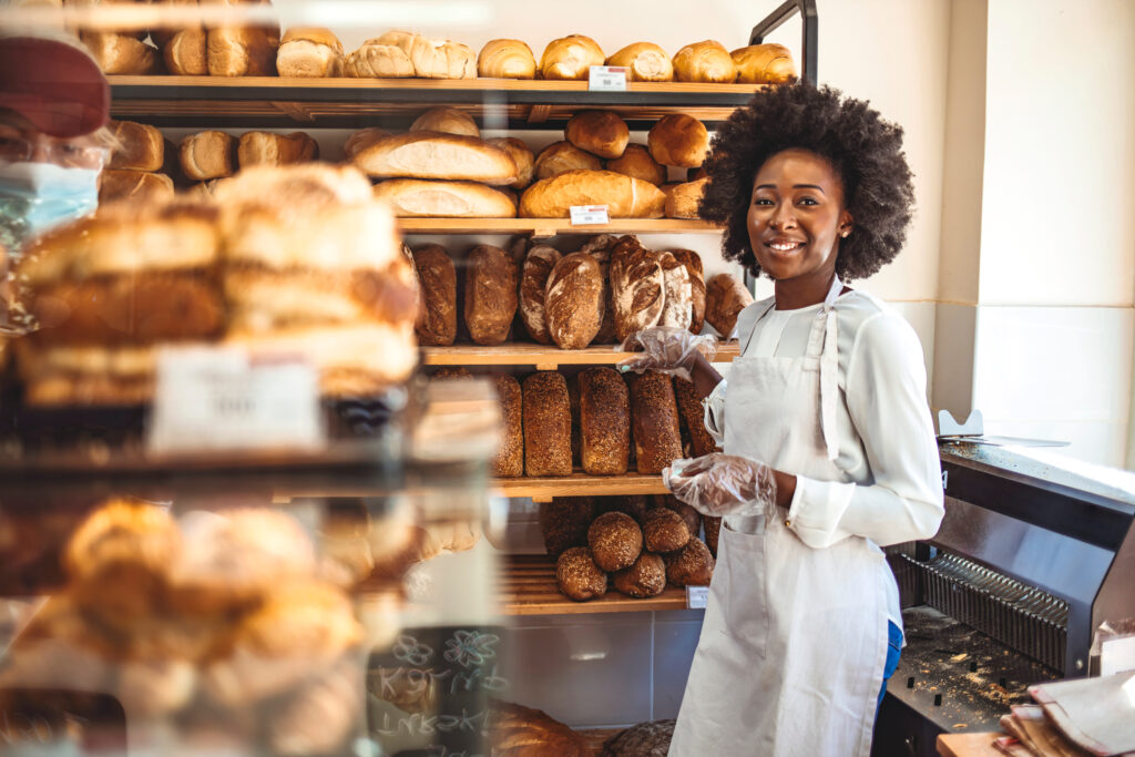 black small business owner standing in front of her bread baked goods in her store