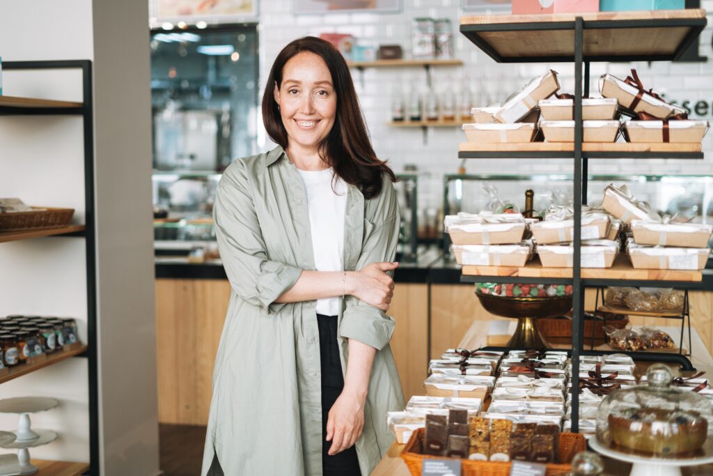 a women-owed business with the owner standing and smiling in front of her shop